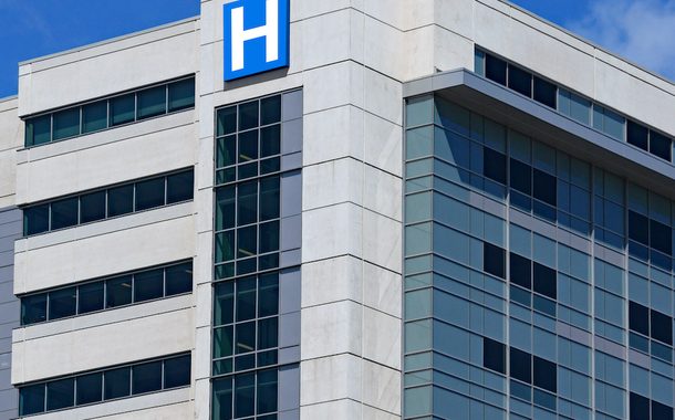 großes modernes Gebäude mit blauem H-Schild für Krankenhaus