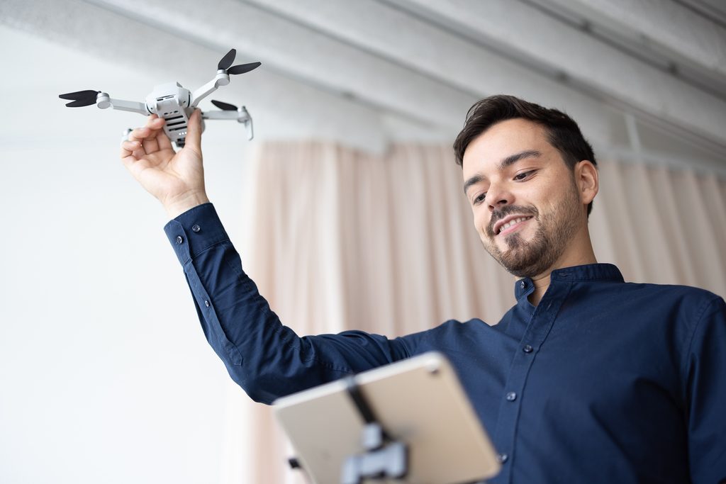 Ramon Sonderegger mit weisser Drone und iPad in der Hand
