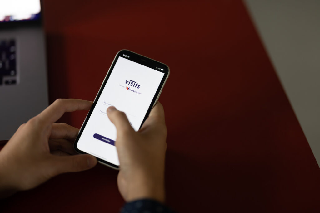 Wüest Visits auf den Handy mit rotem Tisch im Hintergrund